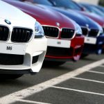 Poland: Driver collides with a BMW at a vehicle dealership.