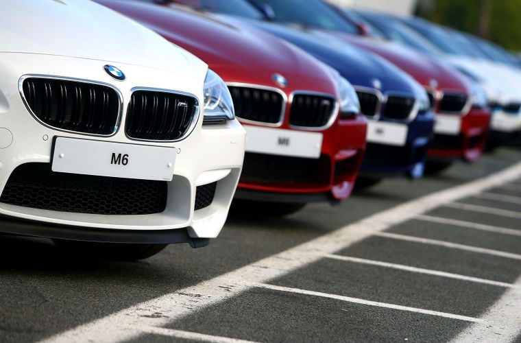 Poland: Driver collides with a BMW at a vehicle dealership.